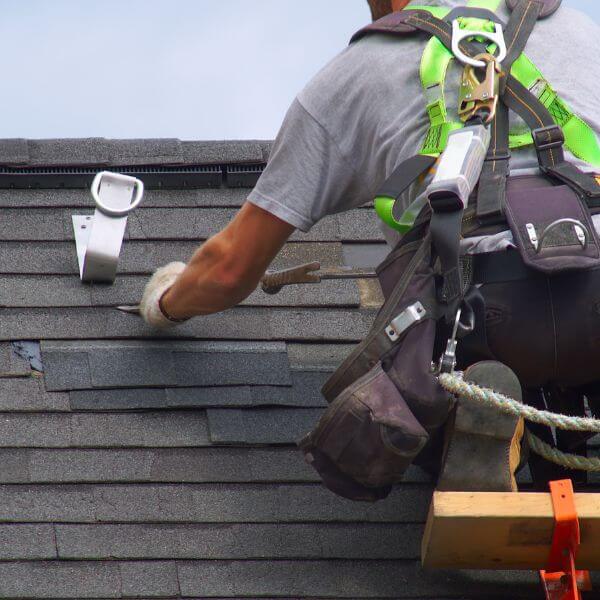 Roofer from Roofing Guys Sydney replacing cracked and lifted shingles during a detailed roof repair in Sydney.