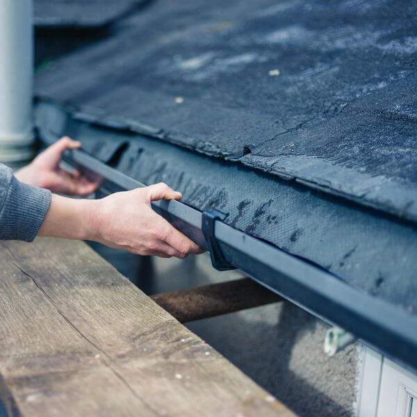 Roofing Guys Sydney technician repairing a residential gutter to fix drainage issues and prevent water damage.