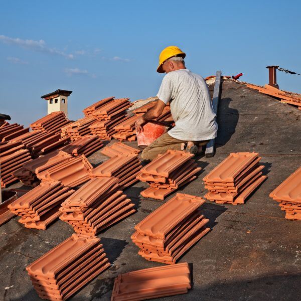 Roofer repairing storm damage and replacing broken tiles as part of a tile roof in Hornsby