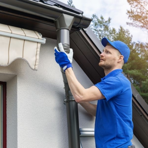 Roofing Guys Sydney installer fitting a new downpipe on a home as part of gutter and downpipe replacement services in Sydney