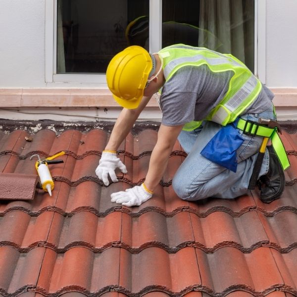 Roofing Guys Sydney roofer repairing and restoring terracotta roof tiles during a professional roof restoration service
