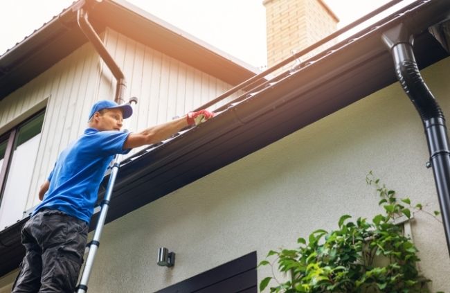 Roofing Guys Sydney technician inspecting and cleaning gutters and downpipes on a residential home in Sydney
