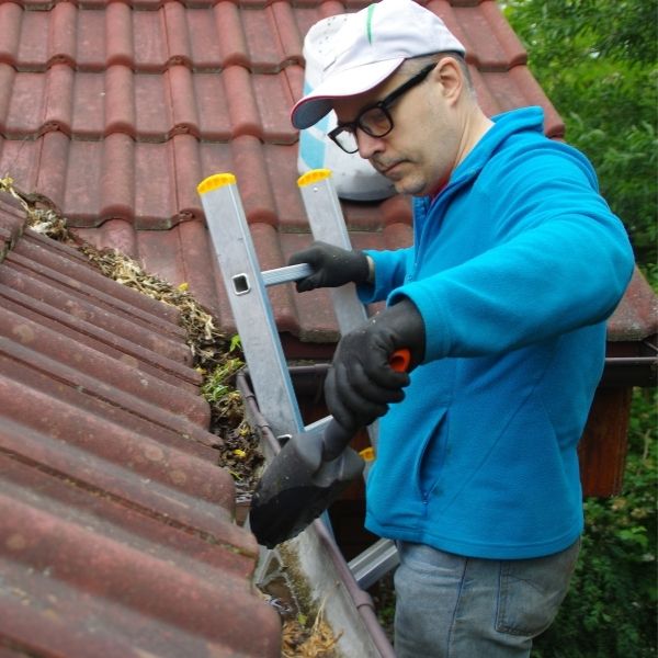 Roofing Guys Sydney gutter cleaning service removing leaves and debris from residential roof gutter